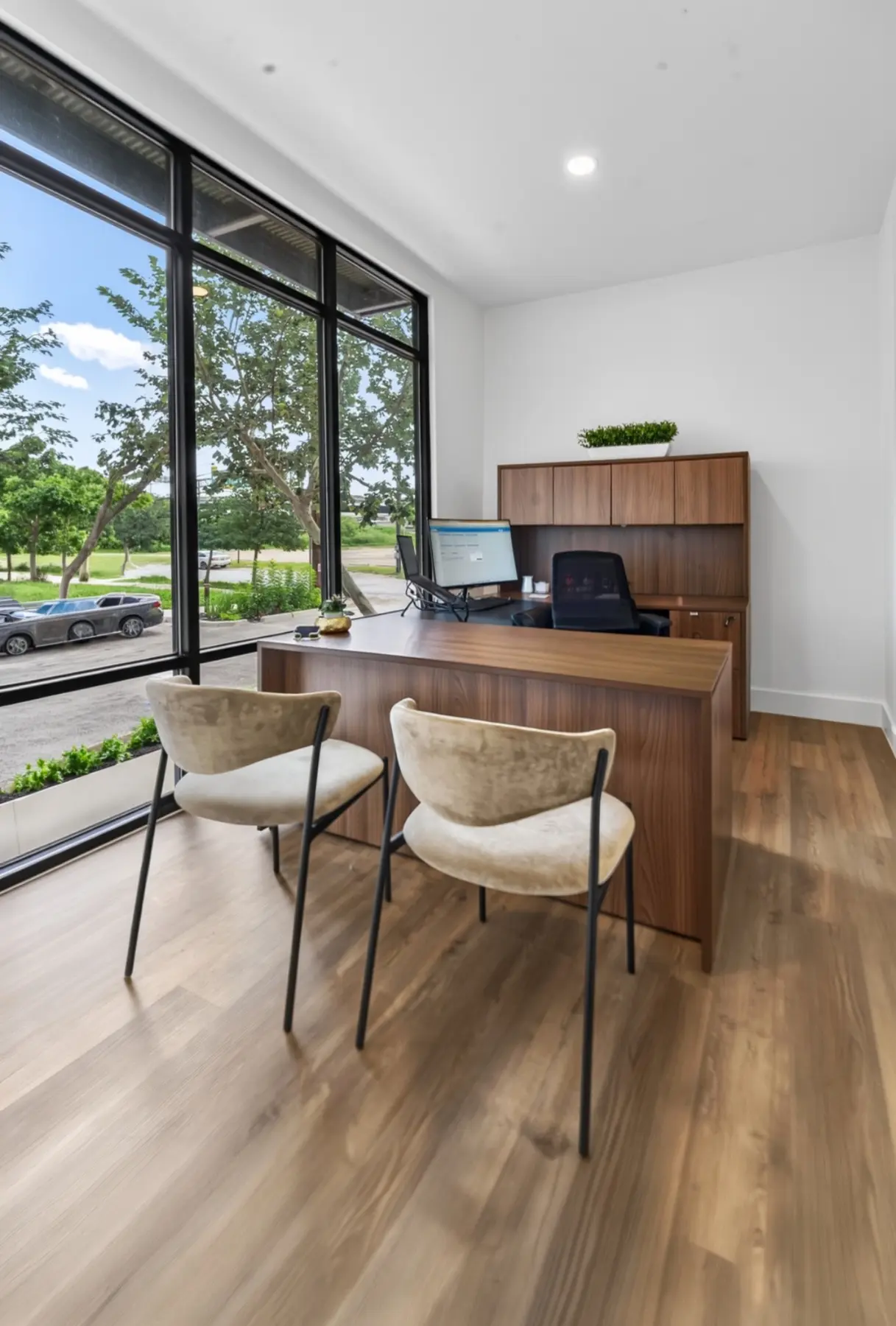 Private leasing office with custom wood desk and floor-to-ceiling windows