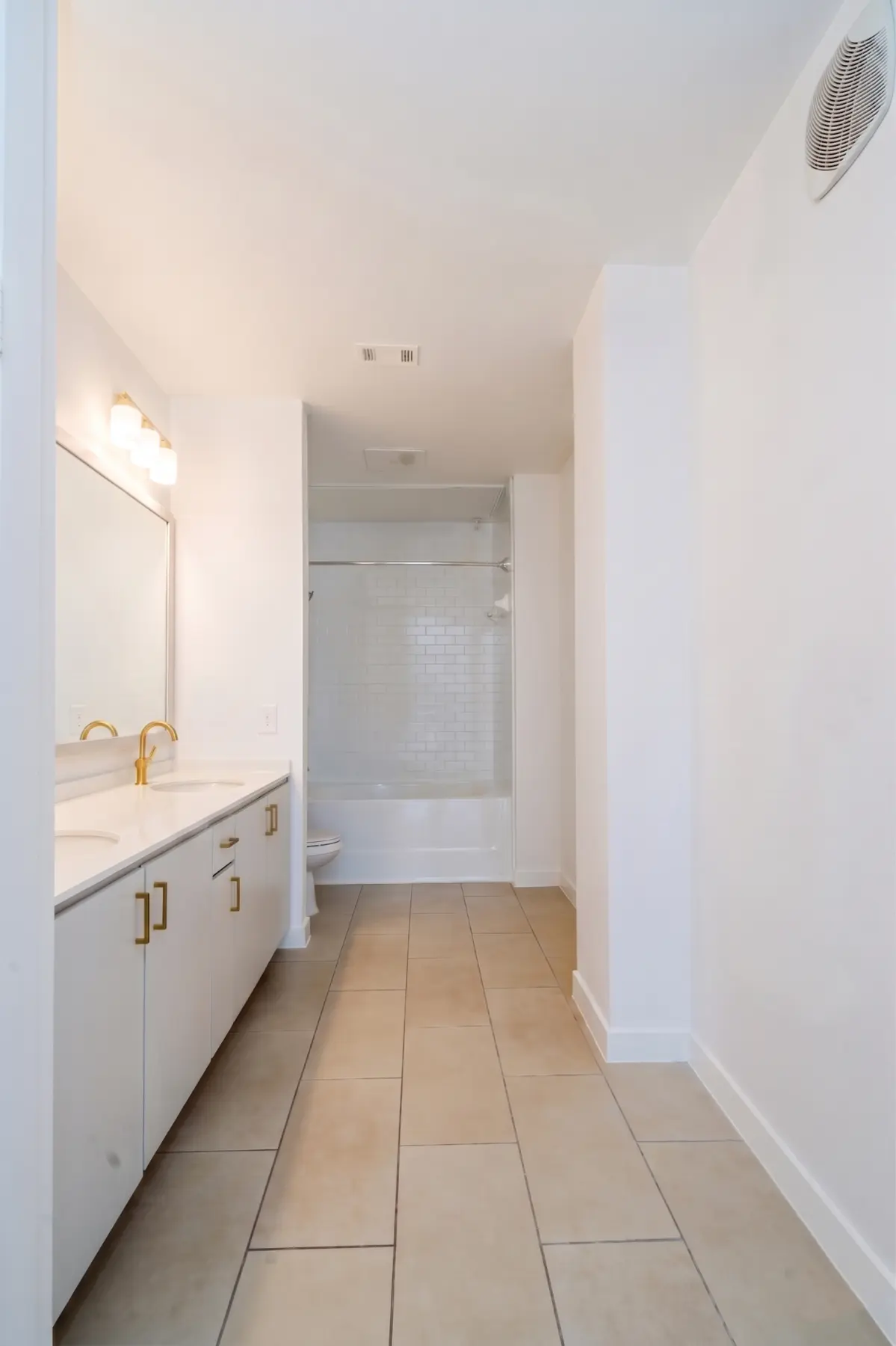 Completed apartment bathroom with new vanity, fixtures, tile, and tub surround