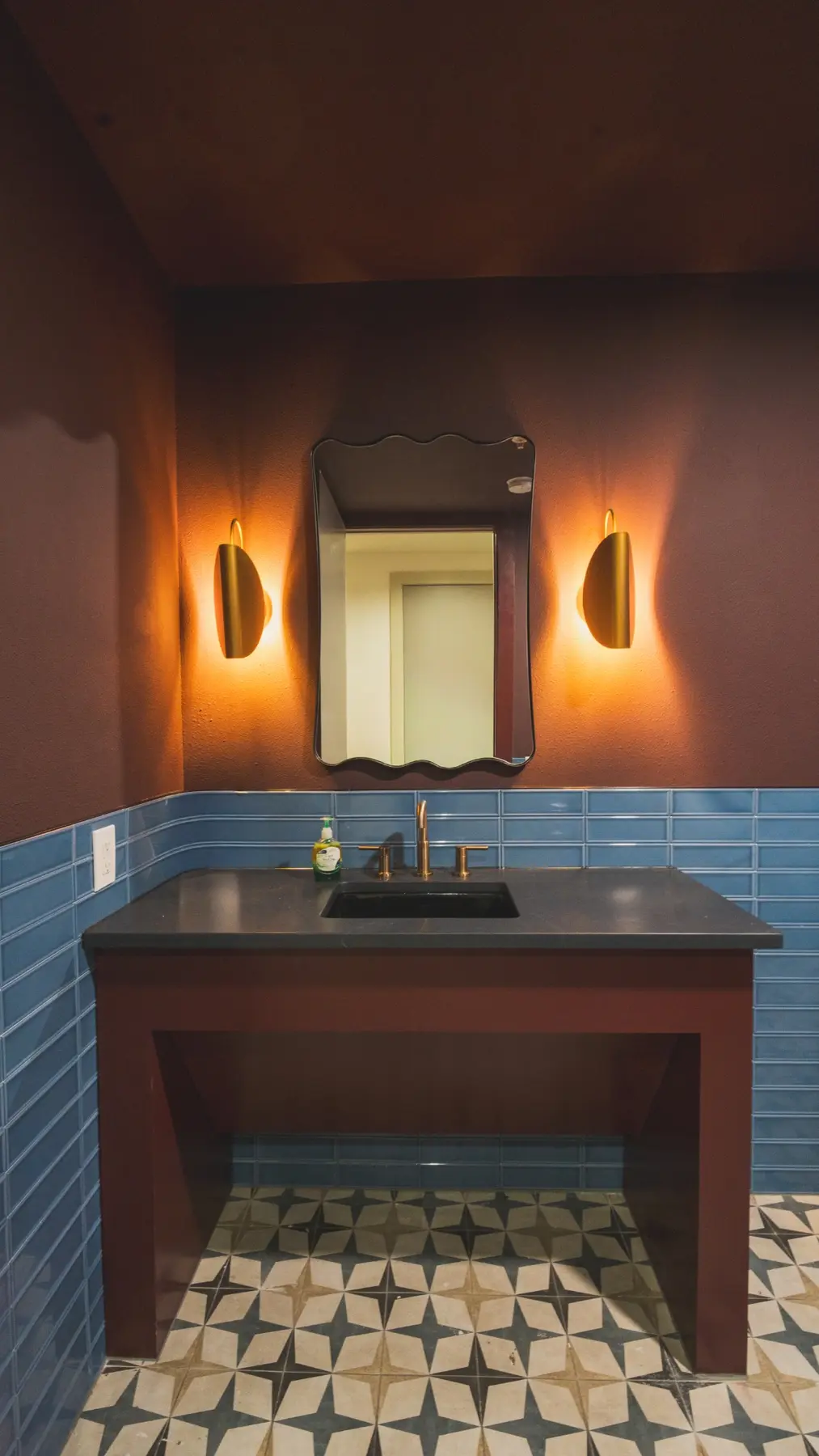 Renovated restroom with custom vanity, tile, and lighting