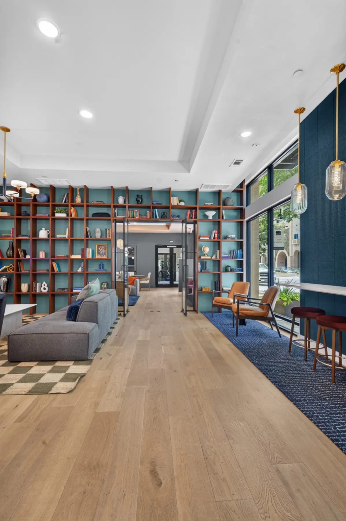 Completed resident lounge with custom wood shelving and floor-to-ceiling windows