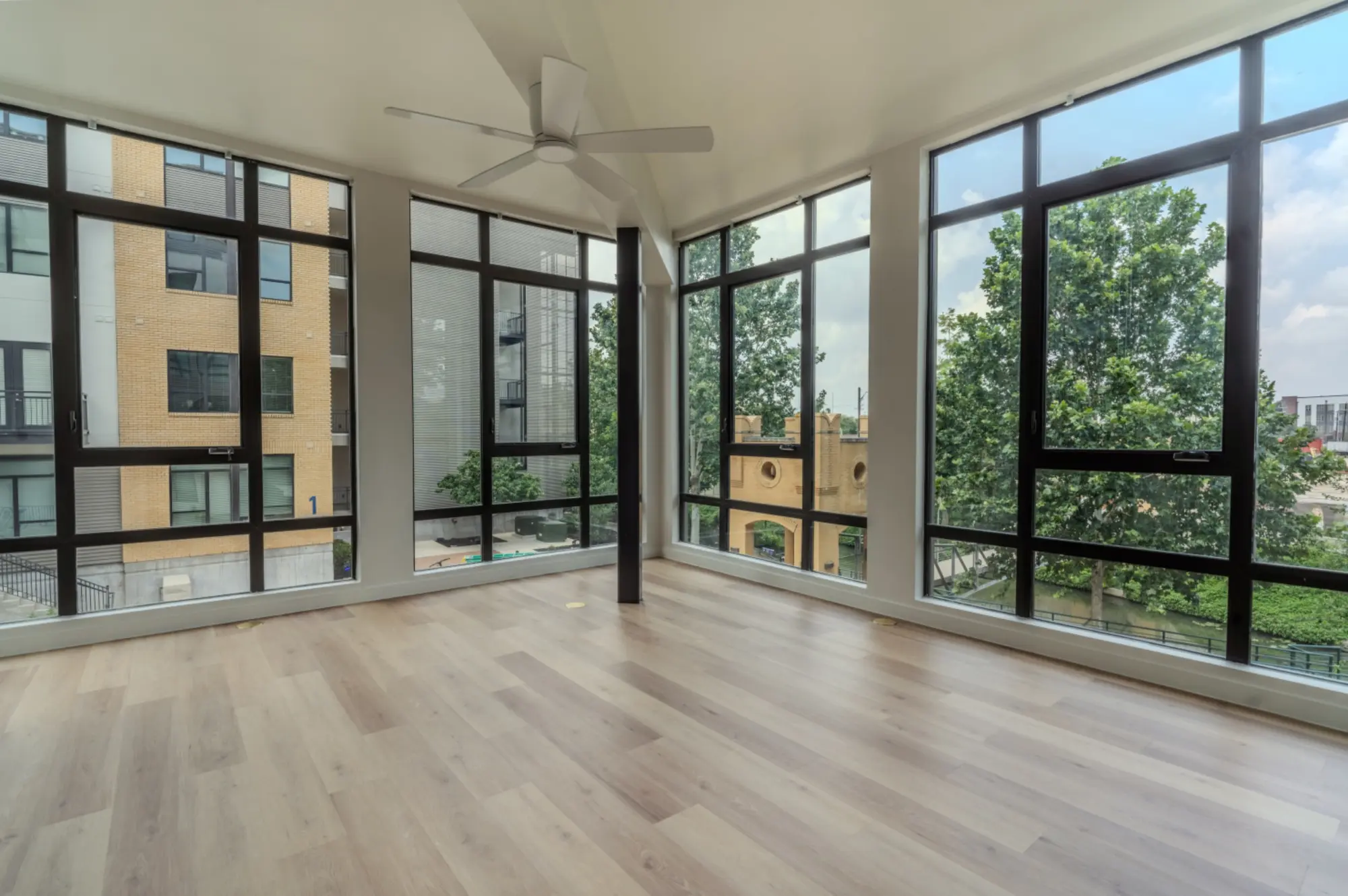 Renovated apartment living room with floor-to-ceiling windows and new flooring