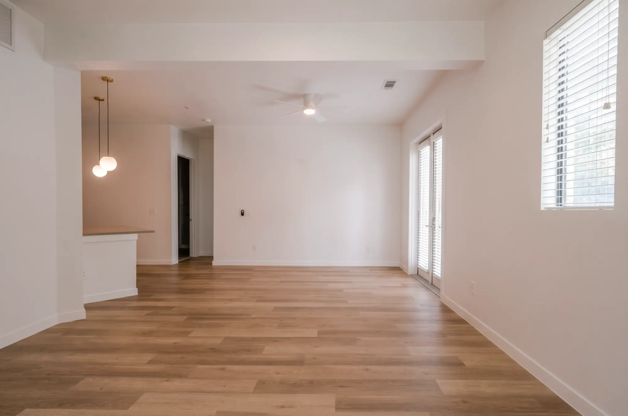 Completed open-plan apartment living and dining area with new flooring, paint, and lighting